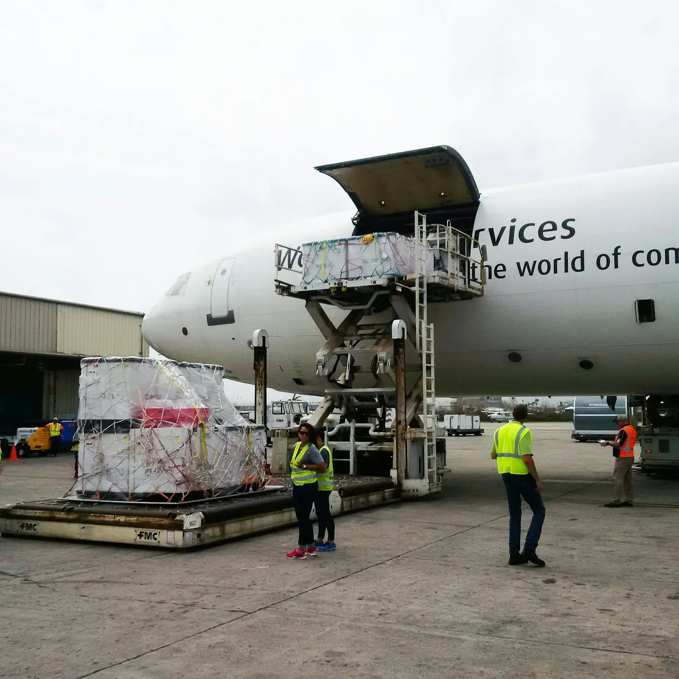 Ground crew loading freight into the hold of a cargo aircraft.