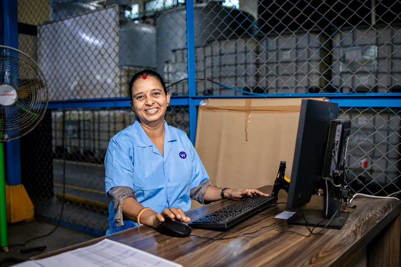 Operations specialist reviewing shipment paperwork at a workstation.