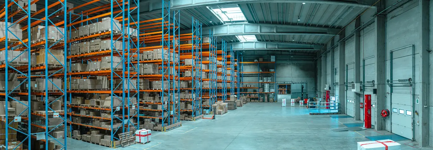 Pallet racking stacked with goods in a modern warehouse.