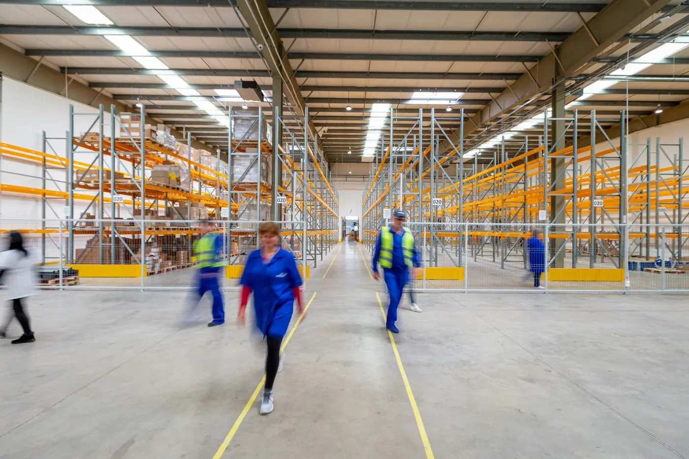 Warehouse staff moving through a high-bay distribution centre.